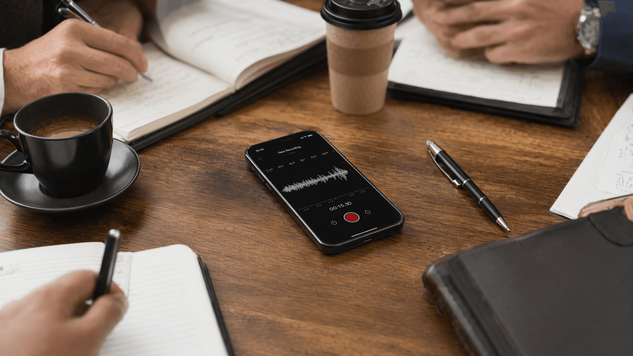 Close-up of a smartphone recording a meeting on a conference table